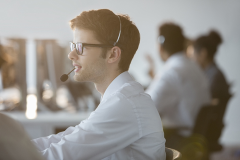 Businessman wearing headset in office stock photo