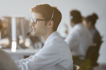 Businessman wearing headset in office - CAIF08176