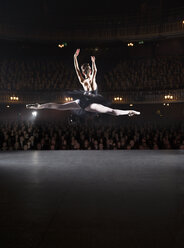 Ballerina mid-air on theater stage - CAIF08226