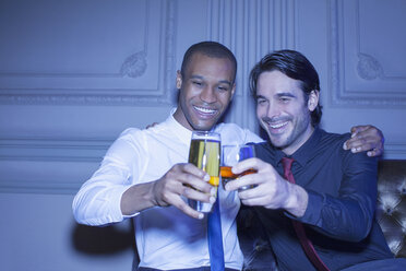 Well dressed men hugging and toasting beer and cocktail - CAIF08264