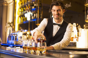 Gut gekleideter Barkeeper schenkt Bourbon in einer Luxusbar aus - CAIF08281