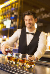 Gut gekleideter Barkeeper schenkt Bourbon in einer Luxusbar aus - CAIF08323