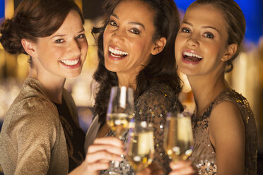Close up portrait of smiling women toasting champagne flutes - CAIF08335