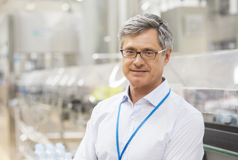 Geschäftsmann lächelnd in Fabrik, lizenzfreies Stockfoto