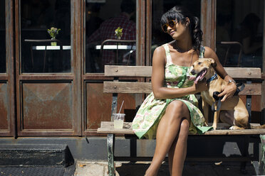 Frau mit Hund auf Bank am Fußweg sitzend - CAVF03322