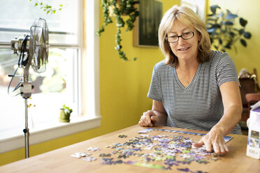 Frau spielt Puzzle zu Hause - CAVF03330