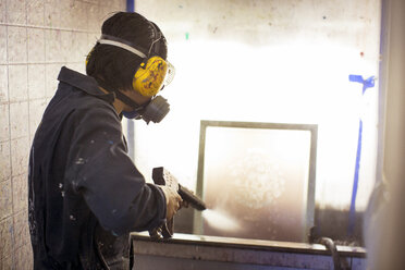 Arbeiter beim Reinigen eines Gestells in einer Fabrik - CAVF03422