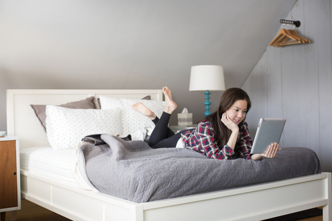 Frau schaut auf Tablet-Computer zu Hause, lizenzfreies Stockfoto