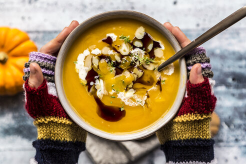 Mädchenhände halten Schüssel mit Kürbiscremesuppe - SARF03603