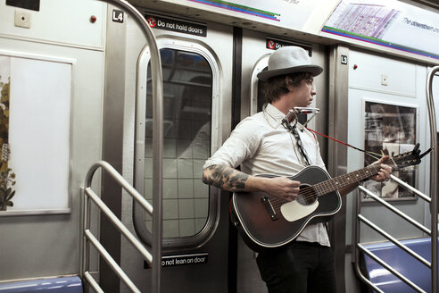 Straßenmusiker spielt Gitarre in der U-Bahn - CAVF03640