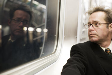 Thoughtful businessman traveling in train - CAVF03669
