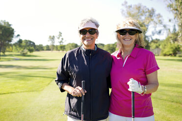 Portrait of women holding stick while standing at golf course - CAVF03688