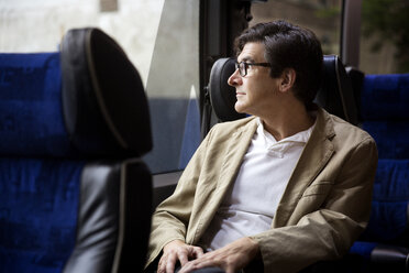 Man looking through window while sitting in bus - CAVF03691