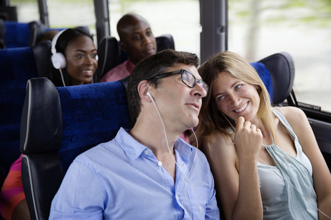 Glückliche Paare sitzen im Bus, lizenzfreies Stockfoto