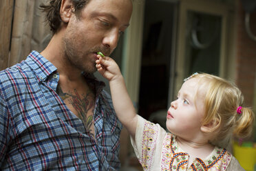 Baby Mädchen füttert Vater zu Hause - CAVF03845