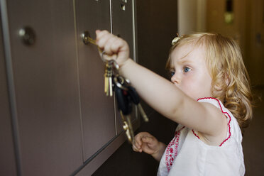 Baby-Mädchen öffnet Schließfach zu Hause - CAVF03862