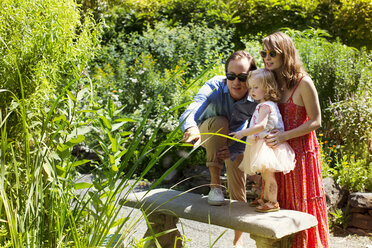 Familie schaut sich Pflanzen im Park an - CAVF03864