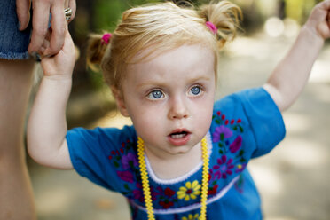 Close-up of baby girl holding mother's hand at street - CAVF03893