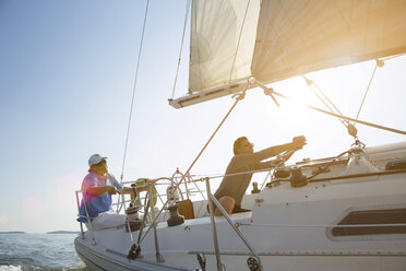 Glückliche Freunde segeln Yacht gegen klaren Himmel - CAVF03925