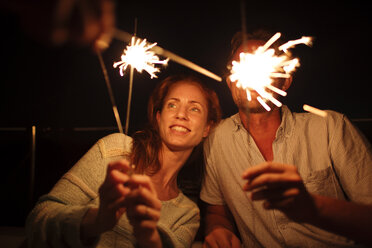 Couple holding sparklers at night - CAVF03961