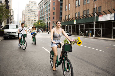 Friends riding bicycle on city street - CAVF03969