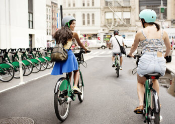 Freunde fahren Fahrrad auf einer Straße in der Stadt - CAVF03979