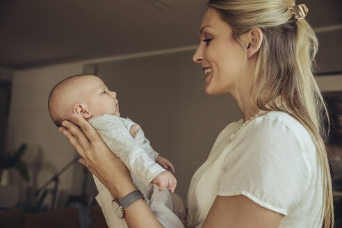 Lächelnde Mutter im Gespräch mit ihrem neugeborenen Baby - MFF04387