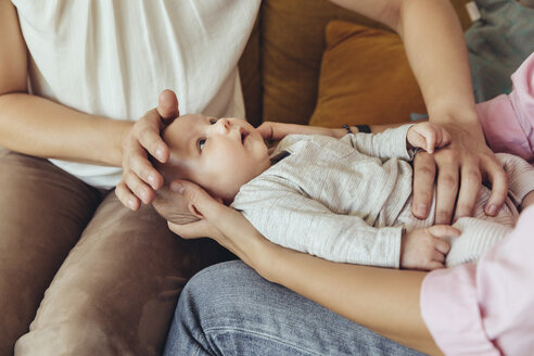 Midwife and mother giving newborn baby a belly massage to help with digestion - MFF04396