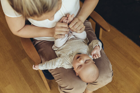 Mutter hält die Füße des Babys hoch, um die Verdauung zu fördern - MFF04399