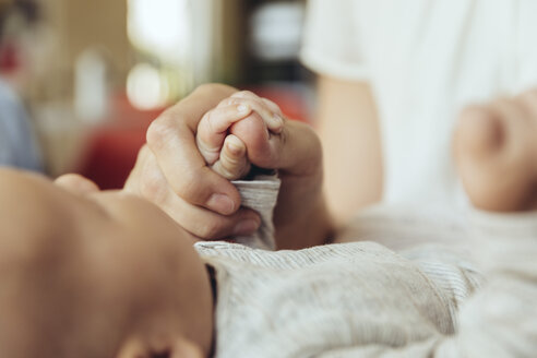 Nahaufnahme einer Mutter, die die Hand ihres neugeborenen Babys hält - MFF04401