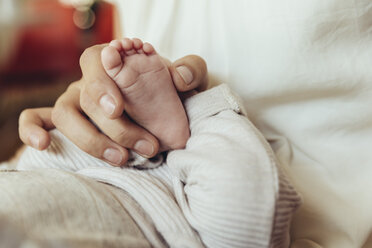Close-up of mother holding newborn baby’s foot - MFF04402