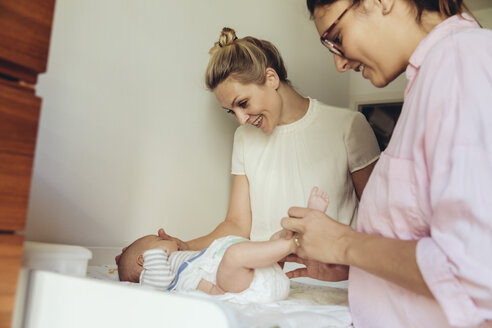 Midwife showing mother how to change diapers of newborn baby - MFF04404