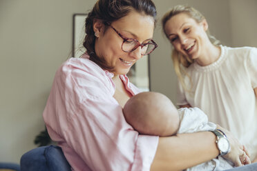 Hebamme unterstützt eine stillende Mutter mit ihrem neugeborenen Baby - MFF04406