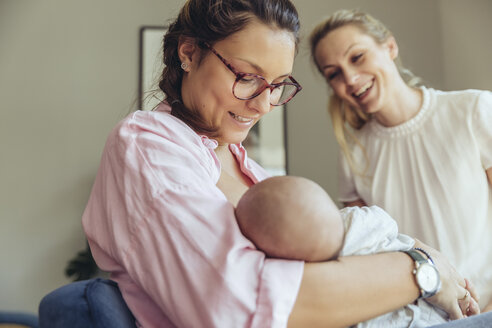 Midwife supporting a breastfeeding mother with her newborn baby - MFF04406