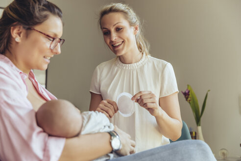 Hebamme hält eine Einwegstilleinlage für die stillende Mutter - MFF04407