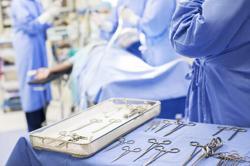 Krankenschwester steht neben einem Tablett mit chirurgischen Instrumenten im Operationssaal - CAIF08428