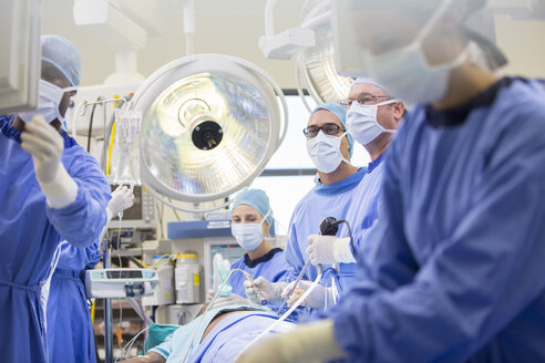Ärzte führen eine Operation im Operationssaal durch und schauen auf den Monitor - CAIF08431