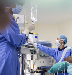 Zwei Chirurgen bereiten medizinische Geräte für eine Operation vor - CAIF08442