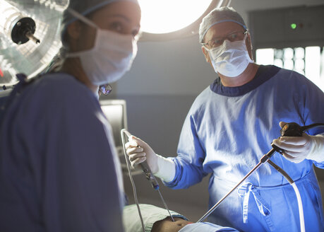 Männliche und weibliche Ärzte bei laparoskopischen Eingriffen im Operationssaal - CAIF08448