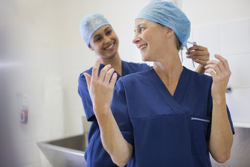 Zwei lächelnde Chirurgen bei der Vorbereitung auf eine Operation - CAIF08451