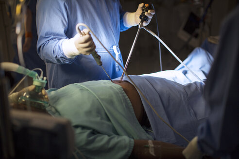 Chirurg, der medizinische Instrumente hält und eine laparoskopische Operation im Operationssaal durchführt - CAIF08458