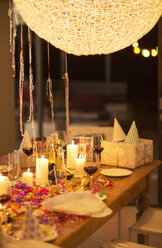 Kerzen und Geschenke auf dem Tisch bei einer Geburtstagsfeier - CAIF08469