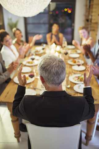 Freunde applaudieren bei einer Dinnerparty, lizenzfreies Stockfoto