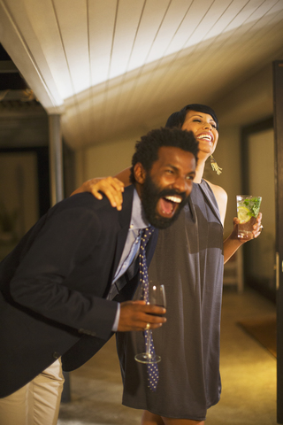 Paar lacht zusammen auf einer Party, lizenzfreies Stockfoto