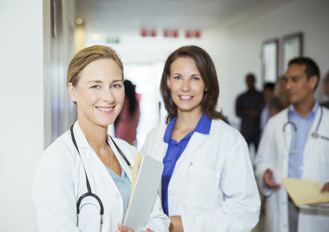 Lächelnde Ärzte auf dem Krankenhausflur, lizenzfreies Stockfoto