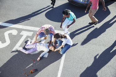 Menschen untersuchen ein verletztes Mädchen auf der Straße - CAIF08523