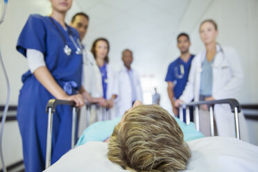 Ärzte und Krankenschwestern schieben einen Patienten durch den Krankenhausflur - CAIF08531