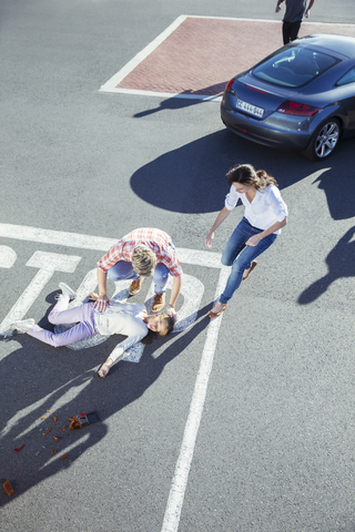 Menschen eilen zu einem verletzten Mädchen auf der Straße, lizenzfreies Stockfoto