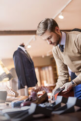 Businessman browsing socks in menswear shop - CAIF08610