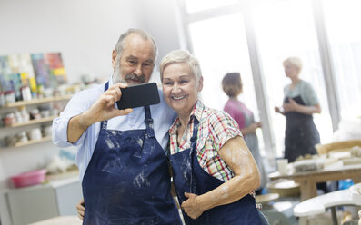 Älteres Paar macht Selfie in Töpferwerkstatt - CAIF08624